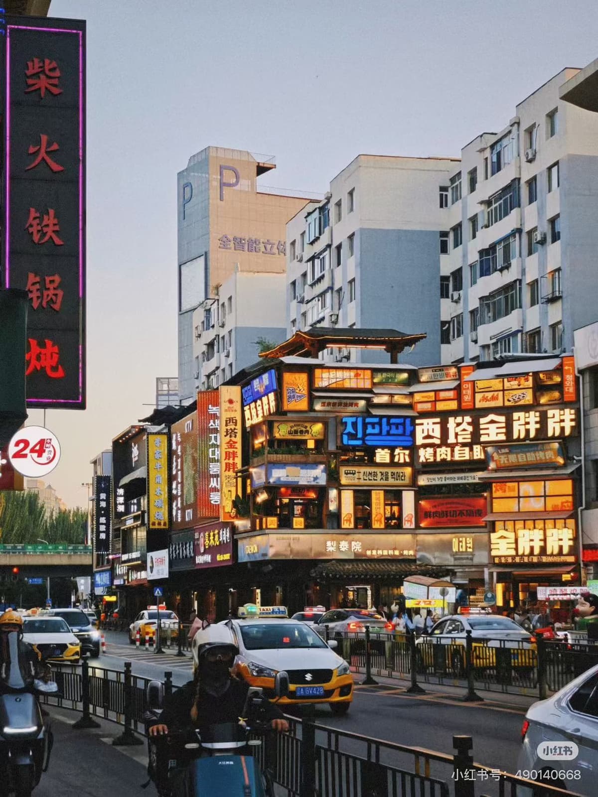 Evening neon and restaurant fronts along Xita Street in Shenyang with diners at grill tables